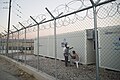Inhabitants of Suda refugee camp seen through barbed wire fence surrounding it, Chios, Grece, Aegean Sea. 29 September, 2016.jpg