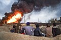 Local boys observing cityscape of Qayyarah town on fire.The Mosul District, Northern Iraq, Western Asia. 09 November, 2016.