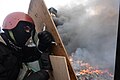 Masked protester holding protective positions behind an improvised wooden shield. Clashes in Ukraine, Kyiv. Events of February 19, 2014