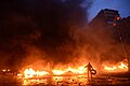 Protester throwing Molotov cocktails to the fire set by the protesters to prevent internal forces from crossing the barricade line. Kyiv, Ukraine. Jan 22, 2014