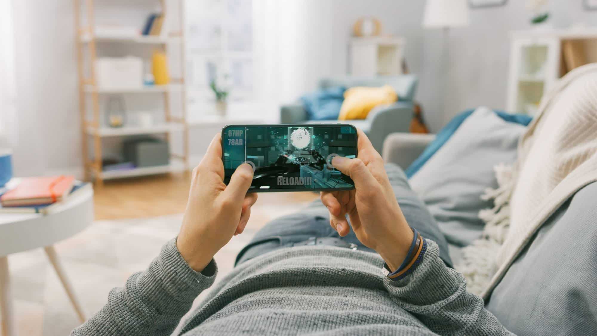 Lying on sofa playing game on phone