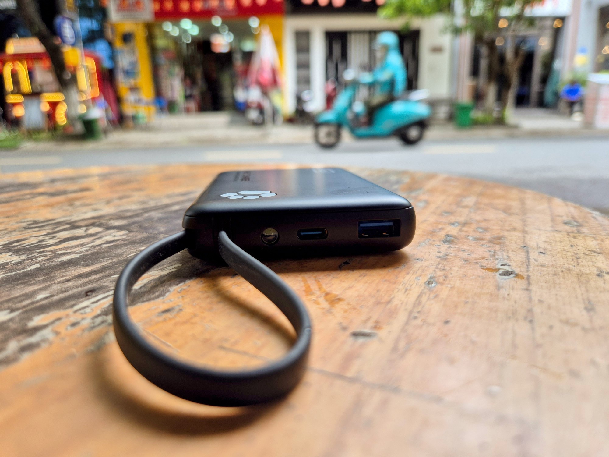 Power bank on wooden table beside street in Vietnam