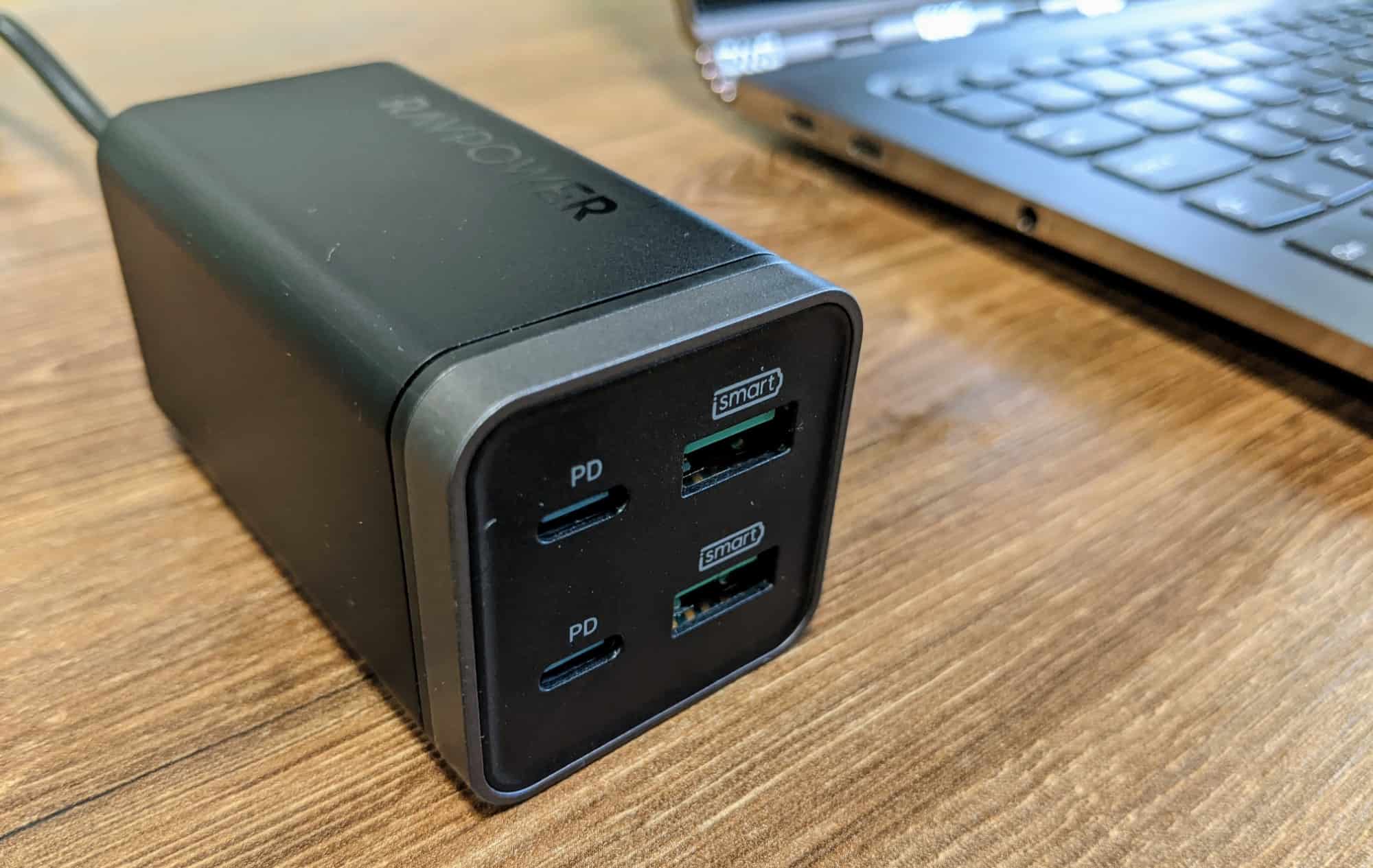 RAVPower PD Pioneer 65W charger with laptop in background