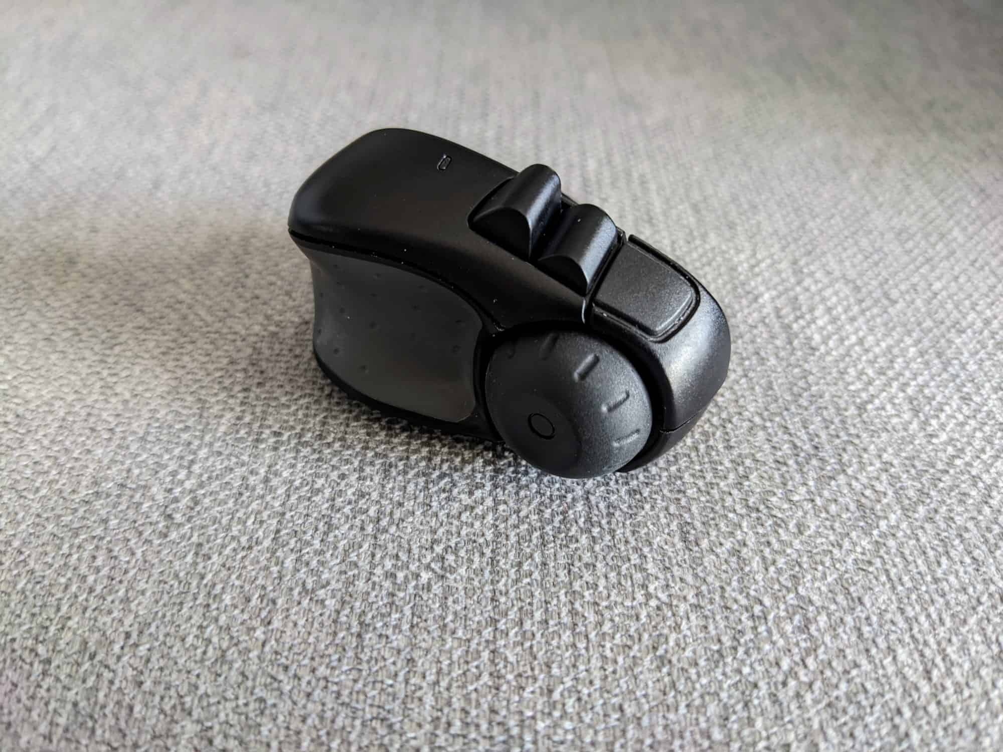 Side-on view of Swiftpoint ProPoint mouse sitting on plain fabric