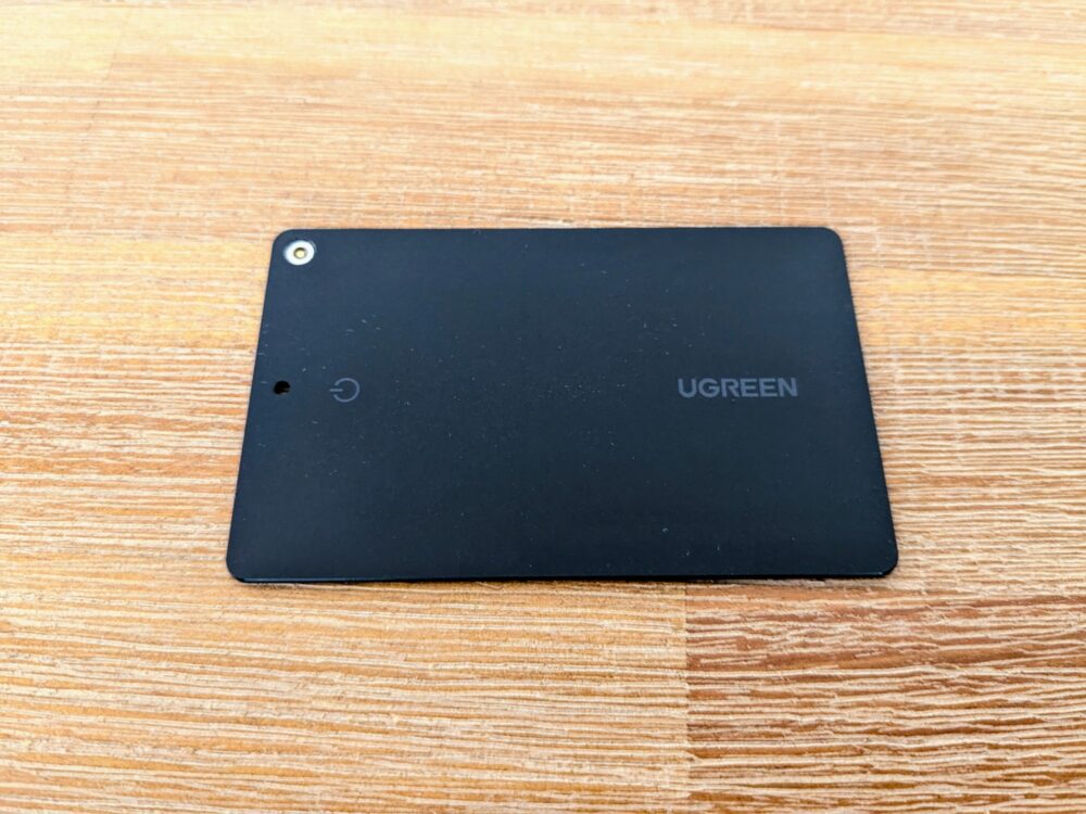 Black credit-card sized tracker on wooden table